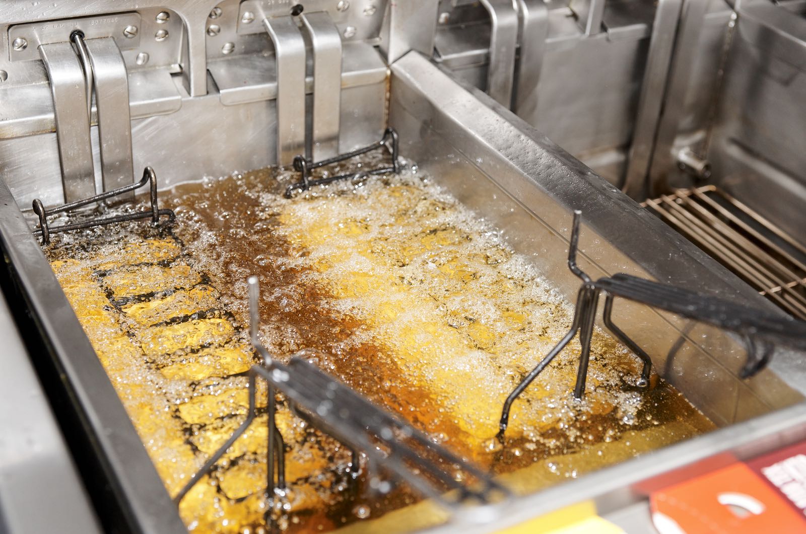 Deep fryer with boiling oil on restaurant kitchen